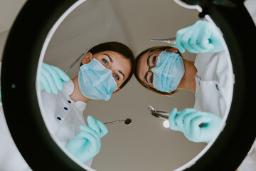 2 dentists looking at patient.