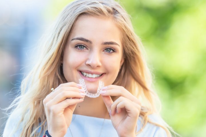 Teenager putting in Invisalign clear aligners.