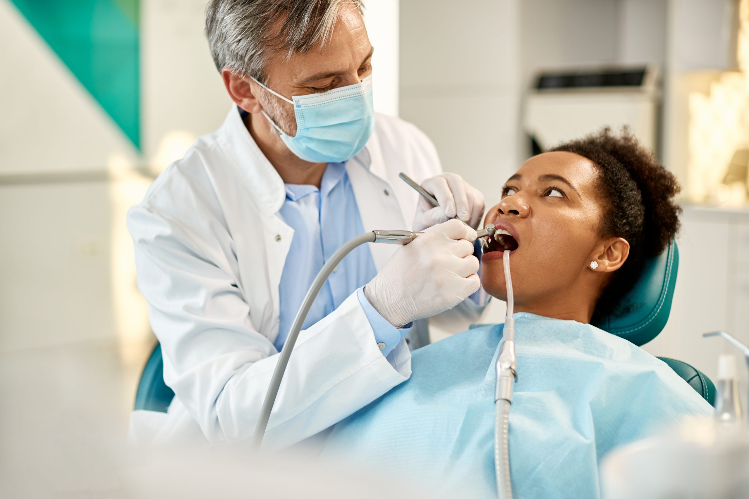 Woman laying in dental chair while dentist is working on her teeth